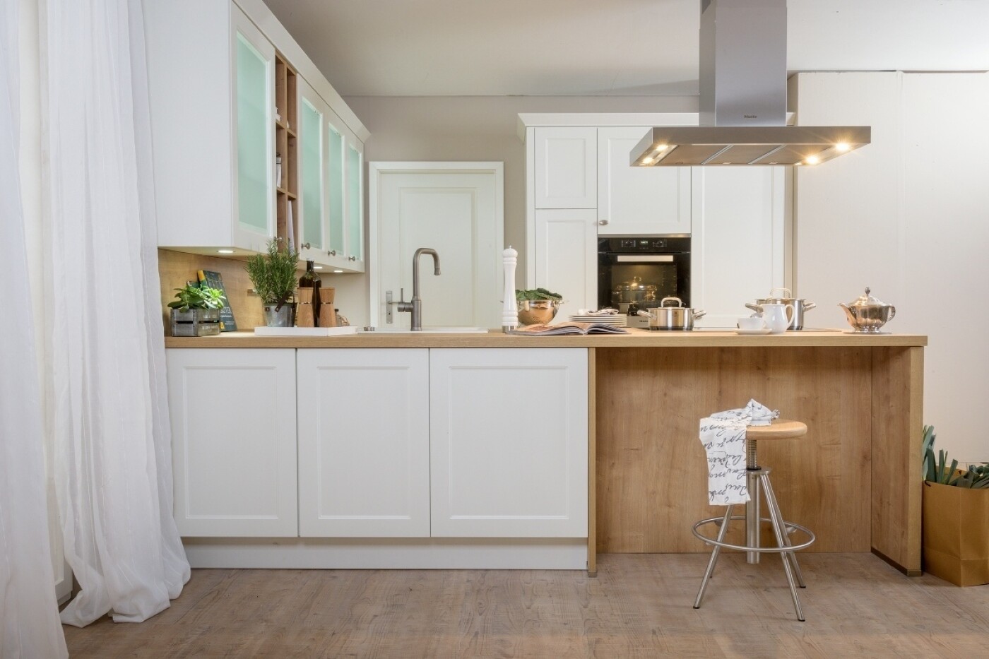 Freistehende Küchentheke, die rückseitig mit Unterschränken und einem Barbereich ausgestattet ist Freistehende Küchentheke, die rückseitig mit Unterschränken und einem Barbereich ausgestattet ist